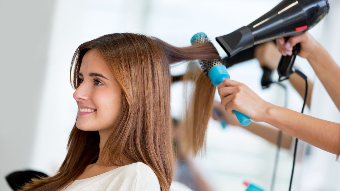 Styliste capillaire en action, coiffant un client dans notre salon de coiffure du Val d'Oise.