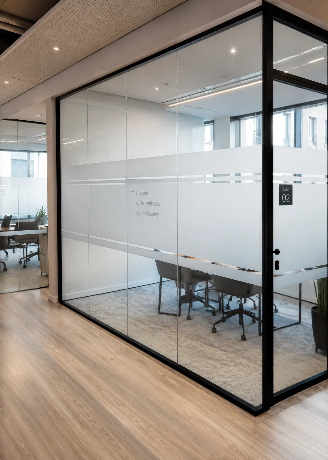 Salle de r&eacute;union vitr&eacute;e avec film d&eacute;poli et vitrophanie int&eacute;rieure dans des bureaux &agrave; Clichy, pour am&eacute;liorer la confidentialit&eacute;, la luminosit&eacute; et le confort visuel.