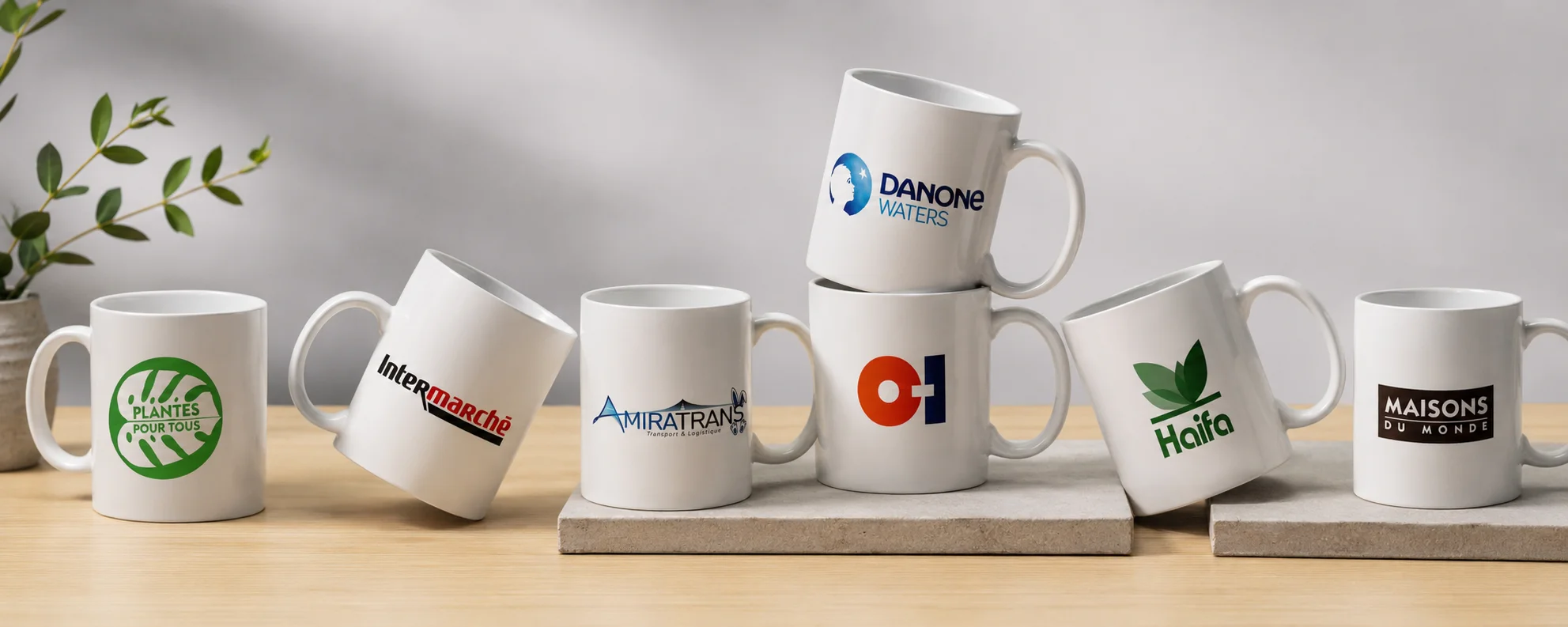 Banni&egrave;re pr&eacute;sentant plusieurs mugs personnalis&eacute;s r&eacute;alis&eacute;s par Kom&eacute;r&egrave;s pour un m&ecirc;me client, avec diff&eacute;rents marquages et mises en sc&egrave;ne pour illustrer le savoir-faire en objets publicitaires personnalis&eacute;s.