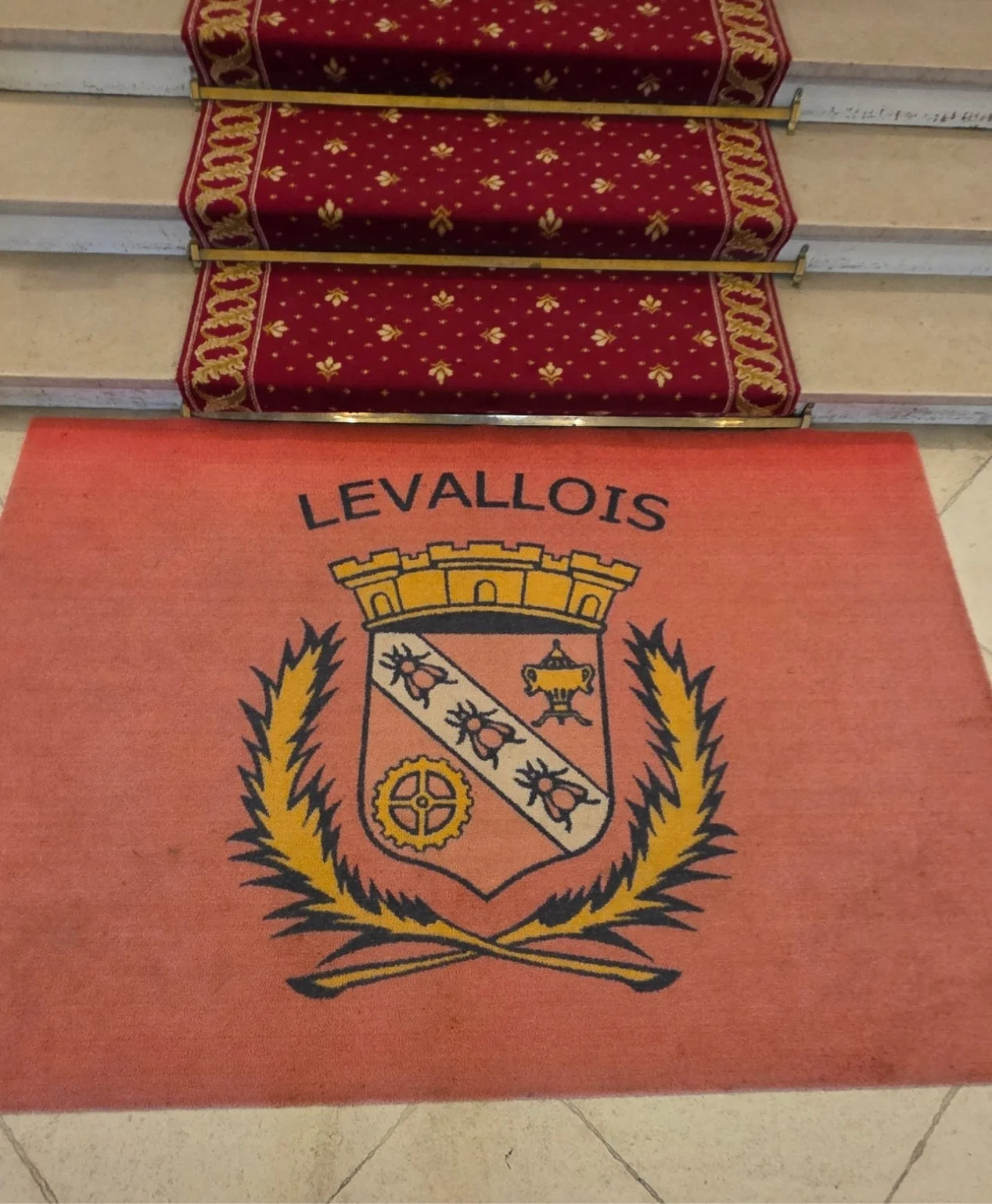 Photo de l&rsquo;ancien tapis personnalis&eacute; de la Ville de Levallois-Perret, install&eacute; dans le hall de l&rsquo;H&ocirc;tel de Ville, &eacute;tudi&eacute; par Kom&eacute;r&egrave;s avant la fabrication d&rsquo;un nouveau tapis logo sur mesure aux couleurs de la commune.